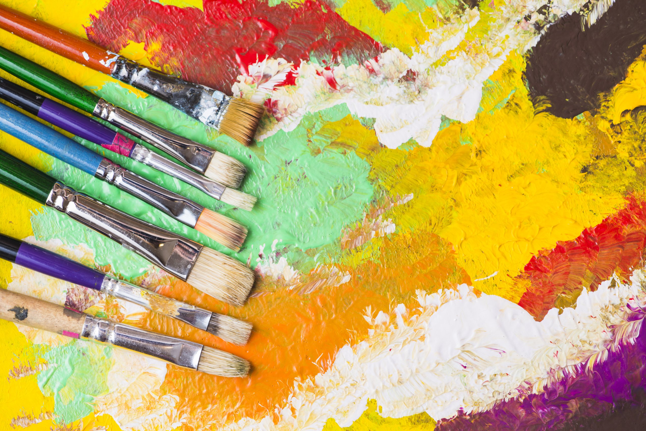 zes penselen met verschillende kleuren erop