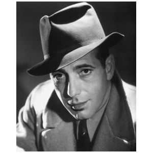 een man in een pak en hoed poseert voor een foto