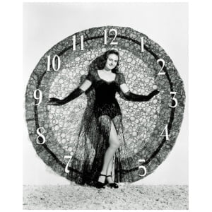 een vrouw die voor een gigantische klok staat