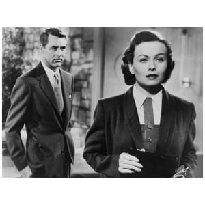 een vrouw in pak en stropdas die naast een man staat