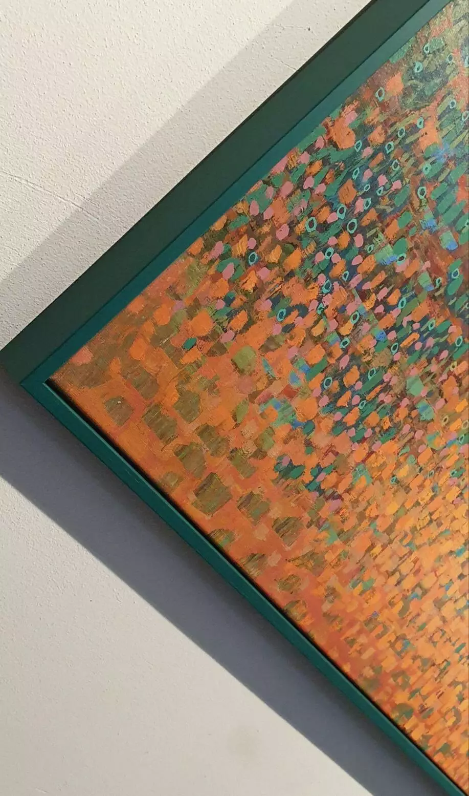 een oranje en groen schilderij aan de muur